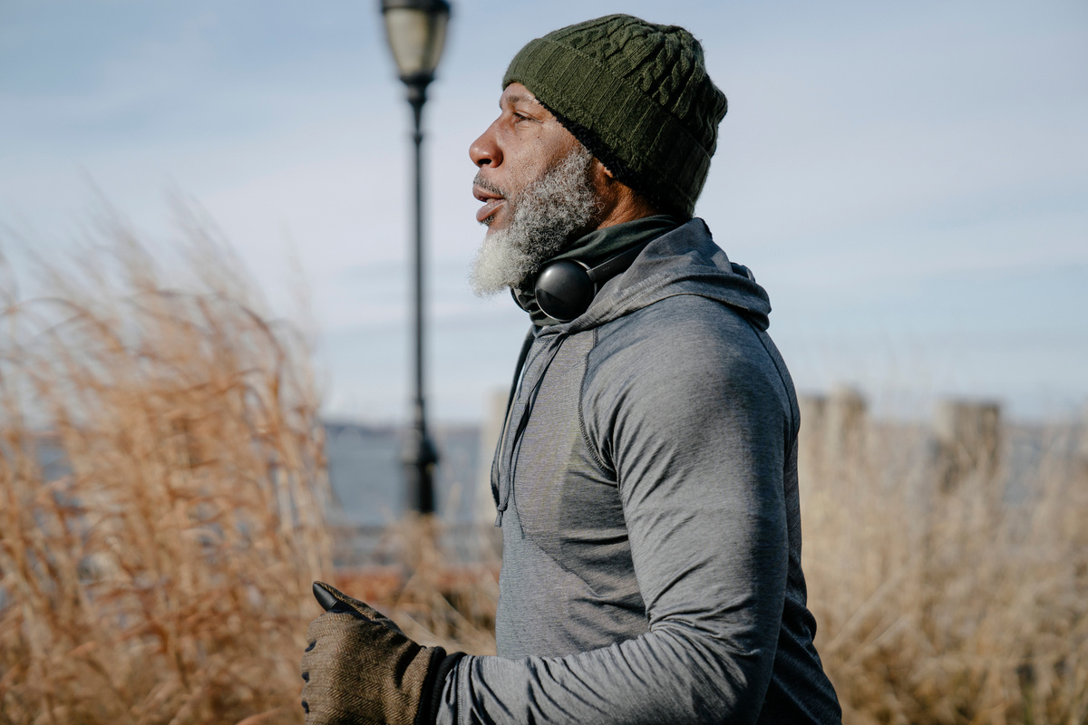 Focused elderly black man running near sea